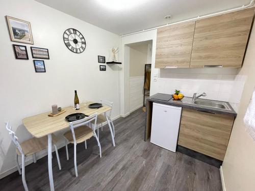 une cuisine avec un évier et une table avec des chaises dans l'établissement L'indépendant - Lumineux, moderne - Gare à 5 min, à Besançon