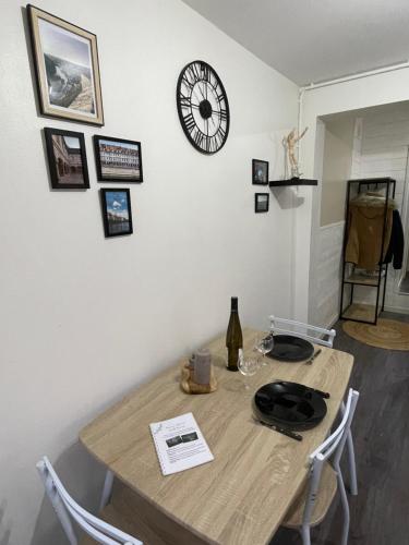 une table à manger avec une horloge sur le mur dans l'établissement L'indépendant - Lumineux, moderne - Gare à 5 min, à Besançon