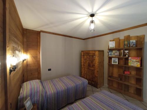 1 dormitorio con cama, lámpara y estante en La Randoulino, en Pomaretto