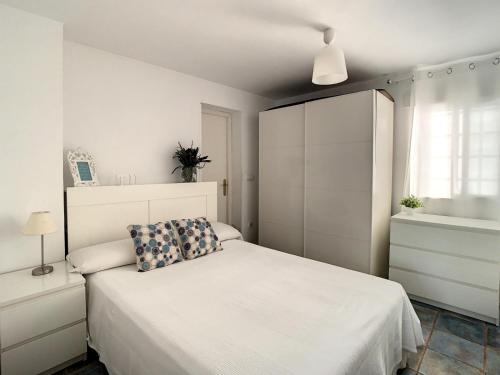 アリカンテにあるLa Casita del Faroのベッドルーム(白いベッド1台、白いキャビネット付)