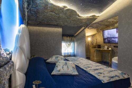 a bedroom with a blue bed with a rock ceiling at Suite Dreams Montecatini in Montecatini Terme