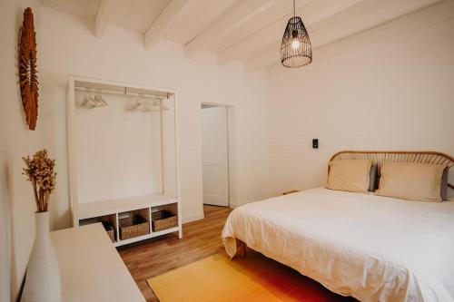 ein weißes Schlafzimmer mit einem Bett und einem Fenster in der Unterkunft Sous le Saule, entre lac et océan in Naujac-sur-Mer
