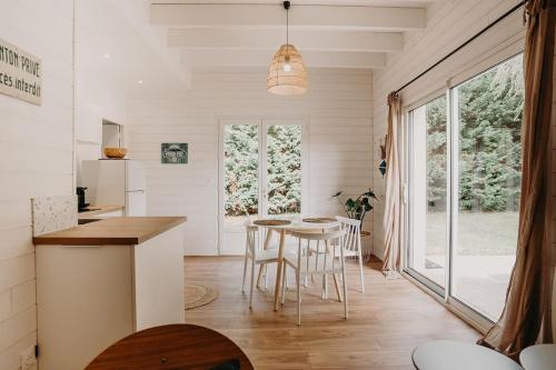 une cuisine et une salle à manger avec une table et des chaises dans l'établissement Sous le Saule, entre lac et océan, à Naujac-sur-Mer
