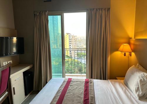 a hotel room with a bed and a large window at Padova Hotel in Beirut