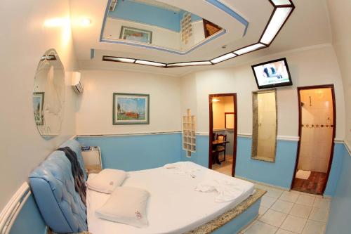 um quarto de hospital com uma cama e um espelho em Hotel & Motel Le Baron em Porto Ferreira