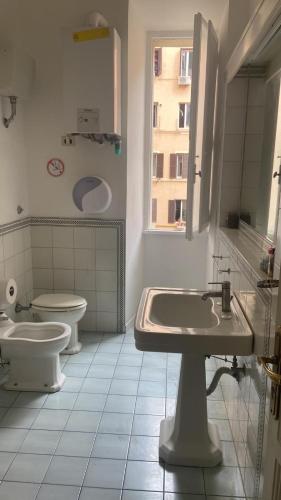 uma casa de banho com 2 lavatórios, um WC e uma janela em Colosseum Point em Roma