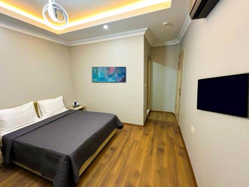 a bedroom with a bed and a flat screen tv at Sisli House By Remar Holding in Istanbul
