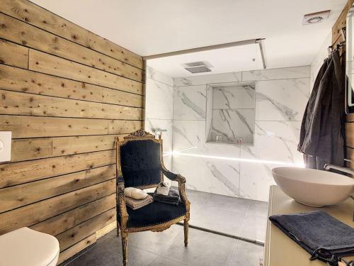 ein Badezimmer mit einem Waschbecken, einem Stuhl und einer Badewanne in der Unterkunft L'ancre céleste in Aywaille