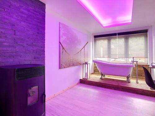 a bathroom with a bath tub in a room with a window at L'ancre céleste in Aywaille