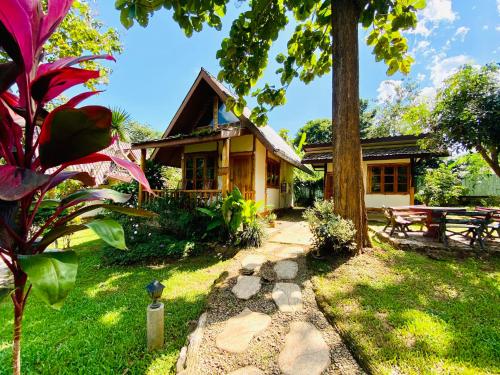 uma casa com uma mesa de piquenique em frente em At Home Chiang Dao, Pooch Lovers em Ban Tham