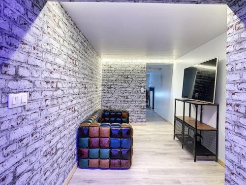 a room with a couch against a brick wall at L'ancre céleste in Aywaille