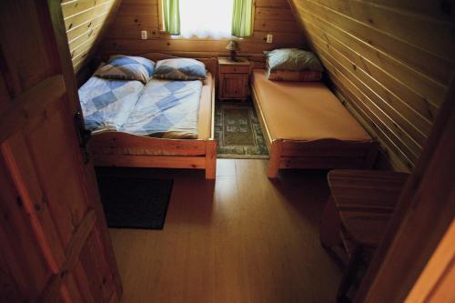 a small room with two beds and a window at Domki Bieszczadnik in Hoczew