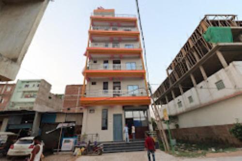 a tall building with people walking in front of it at Hotel Friends Inn ,Jakariyapur in Gulzārbāgh