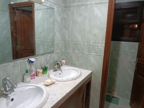 Baño con 2 lavabos y espejo en Villa à la décoration marocaine, en Rabat