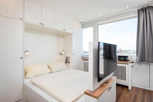 a white room with a couch and a flat screen tv at Exklusive Wohnung im Herzen Westerlands in Westerland