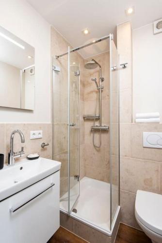 a bathroom with a shower and a toilet and a sink at Exklusive Wohnung im Herzen Westerlands in Westerland