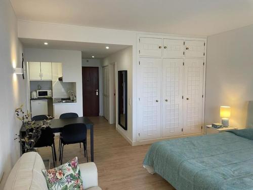 Cet appartement comprend une chambre avec un lit et une table ainsi qu'une cuisine. dans l'établissement Estoril - Bay view apartment, à Estoril
