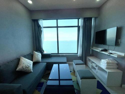 - un salon avec un canapé et une grande fenêtre dans l'établissement Mường Thanh Oceanus Nha Trang, à Nha Trang