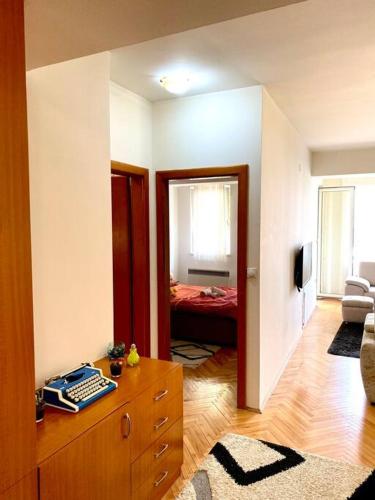 uma sala de estar com um quarto com uma cama e uma cómoda em Tony's Downtown vintage apartment em Skopje