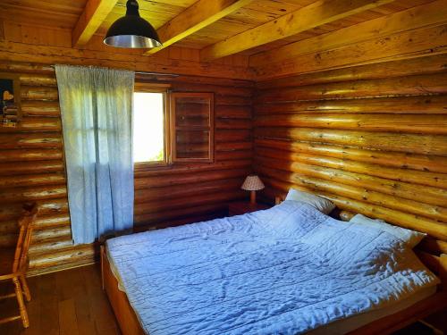 um quarto com uma cama num chalé de madeira em CHALET RONDIN JURA em Aromas