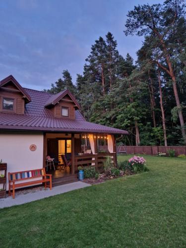 a house with a porch and a yard at Łap Las Pelnik in Pelnik