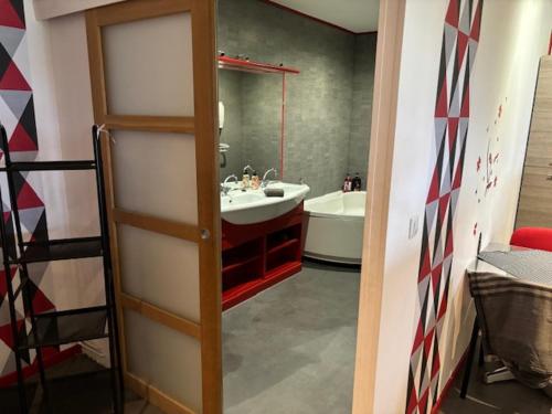 La salle de bains est pourvue d'un lavabo et d'un miroir. dans l'établissement Grand studio avec terrasse, à Vauvert