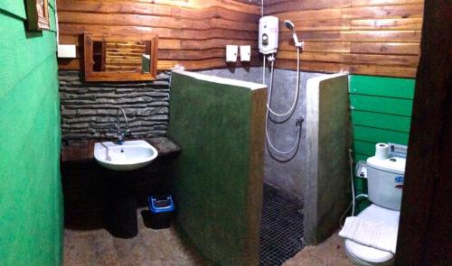 a bathroom with a shower and a toilet and a sink at Whitehouse cafe&Guesthouse in Ban Sa La