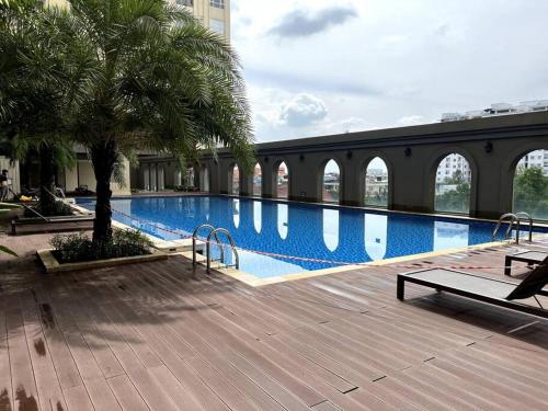 una piscina con una palmera al lado de un edificio en Ho Chi Minh 2 Beds 2 Baths APT, en Ho Chi Minh