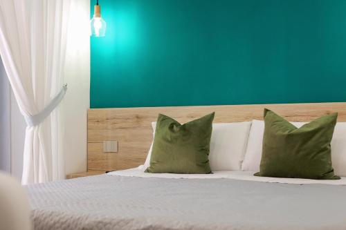 una camera da letto con un letto con cuscini verdi e bianchi di U259 B&b a Napoli