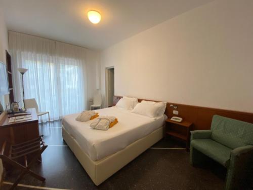 a hotel room with a bed and a chair at Hotel Internazionale in Finale Ligure