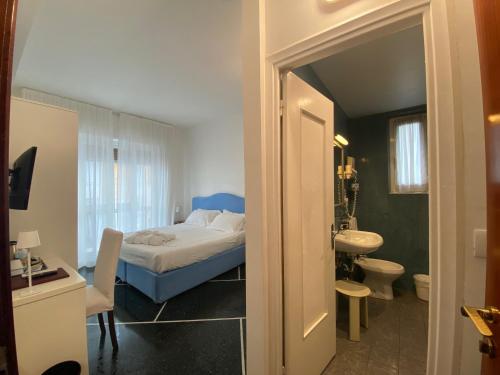 um quarto com uma cama e uma casa de banho com um lavatório em Hotel Internazionale em Finale Ligure