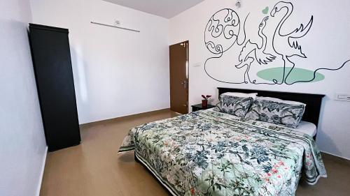 a bedroom with a bed and a wall with a bird mural at Moon Wings Mountain Resort, Kanthalloor in Kanthalloor