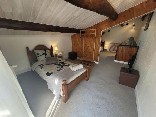 une chambre avec un grand lit dans un grenier dans l'établissement Maison de Village en pierres, à Le Poët