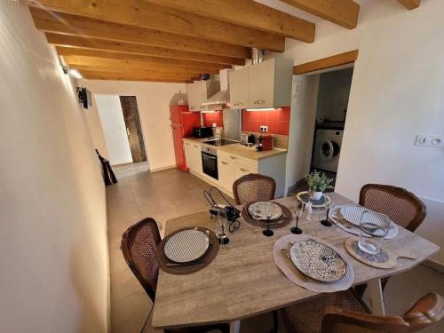 Il dispose d'une cuisine et d'une table à manger avec des chaises. dans l'établissement Maison de Village en pierres, à Le Poët