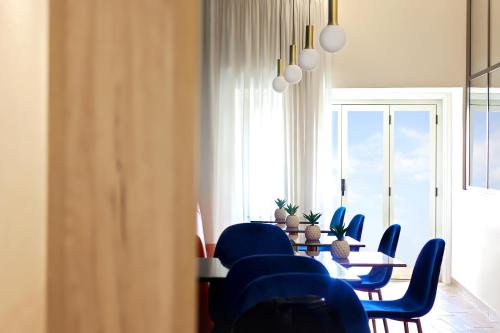 una sala da pranzo con sedie blu, tavolo e finestra di U259 B&b a Napoli