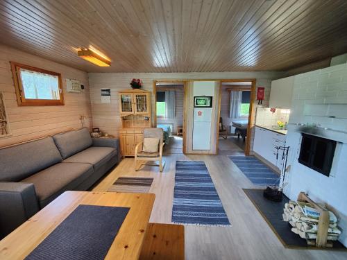 ein Wohnzimmer mit Sofa und Tisch in der Unterkunft Lomavouti Cottages in Savonranta