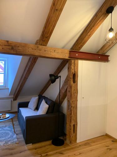 een woonkamer met een bank op de zolder bij Zentrale 1-Zimmer-Wohnung in der Altstadt in Landsberg am Lech