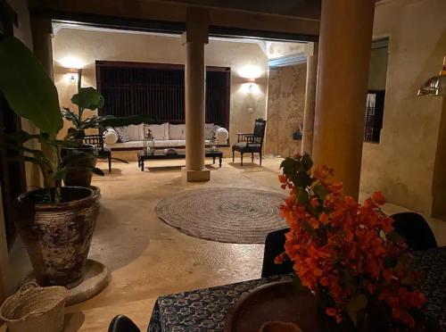a living room with a couch and a table with flowers at Ttunu House in Lamu