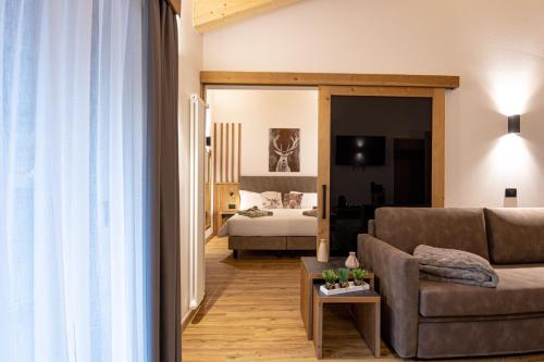 sala de estar con sofá y dormitorio en Hotel Villa Melì, en Predazzo