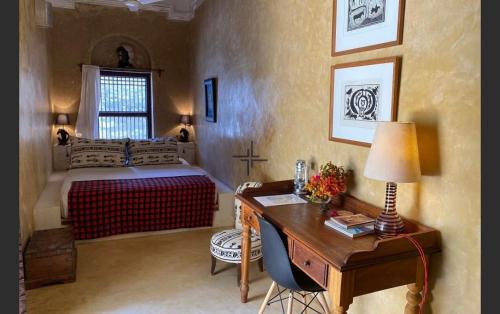 a bedroom with a bed and a desk with a desk at Ttunu House in Lamu