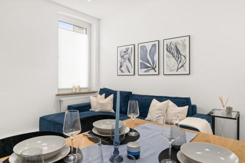 ein Wohnzimmer mit einem blauen Sofa und einem Tisch in der Unterkunft SHINY HOMES - Kitchen - Free Parking - Netflix in Bielefeld