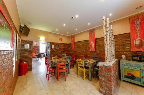 a restaurant with tables and chairs and a brick wall at Do Step Inn Home - Hotel & Hostel in Vienna