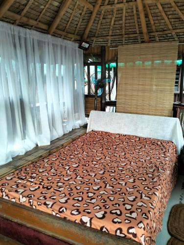 a large bed in a room with white curtains at CFAX Beach House in Campo