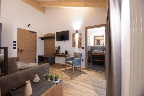 a living room with a couch and a desk at Hotel Villa Melì in Predazzo