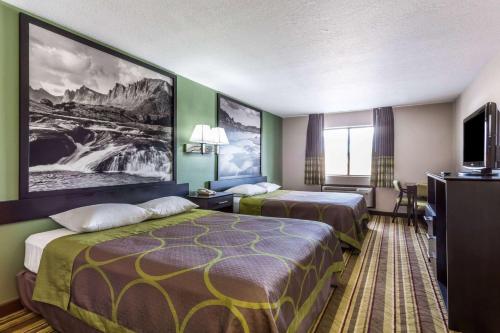 a hotel room with two beds and a flat screen tv at Super 8 by Wyndham Rock Springs in Rock Springs