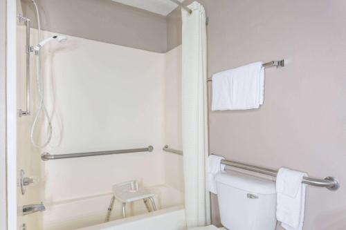 a white bathroom with a shower and a toilet at Super 8 by Wyndham Rock Springs in Rock Springs