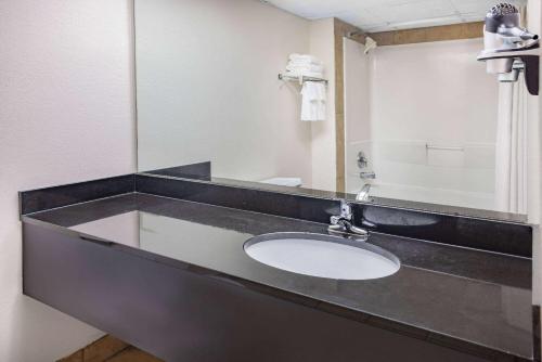 a bathroom with a sink and a mirror at Ramada by Wyndham West Atlantic City in West Atlantic City