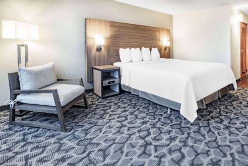 a hotel room with a large bed and a chair at Ramada by Wyndham West Atlantic City in West Atlantic City