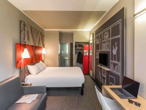 een hotelkamer met een bed en een bank bij ibis Paris Gare de Lyon Ledru Rollin in Parijs
