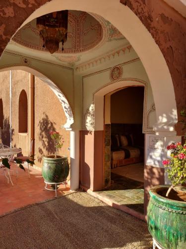 an archway with two potted plants on a patio at Riad ma bonne étoile in Kasr Bounou